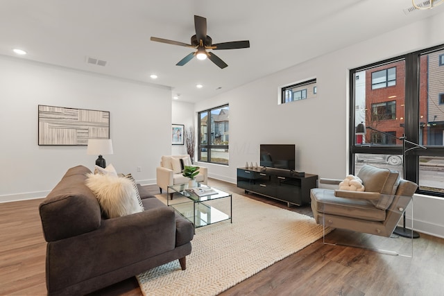 living area with recessed lighting, visible vents, and wood finished floors