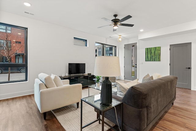 living area featuring recessed lighting, visible vents, a ceiling fan, wood finished floors, and baseboards