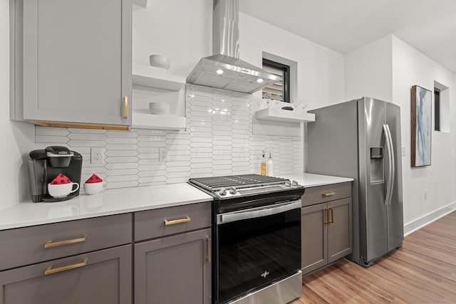 kitchen featuring wall chimney range hood, gray cabinets, appliances with stainless steel finishes, and open shelves