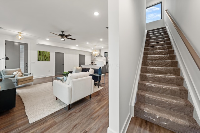 stairway with baseboards, a ceiling fan, wood finished floors, and recessed lighting