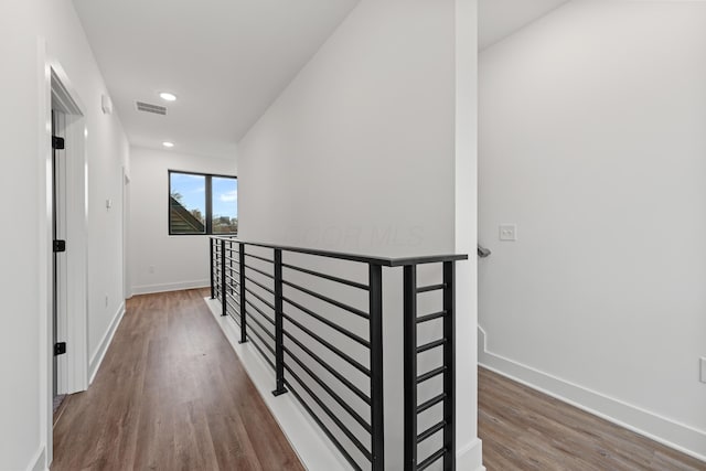 hallway featuring recessed lighting, wood finished floors, an upstairs landing, visible vents, and baseboards