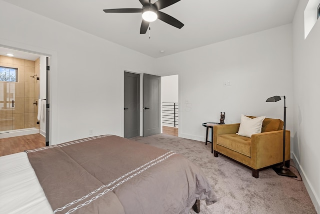 bedroom featuring ensuite bathroom, carpet, a ceiling fan, and baseboards