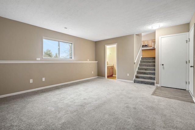 carpeted spare room with a textured ceiling