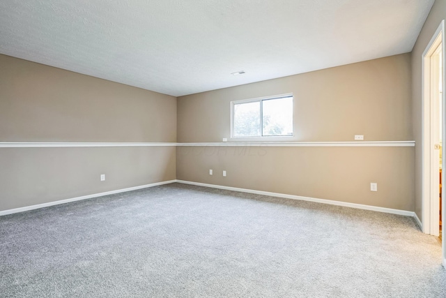 carpeted spare room with a textured ceiling