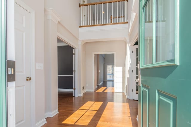 foyer featuring dark wood-type flooring and a towering ceiling