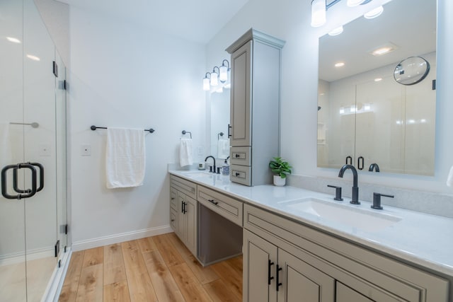 bathroom with vanity, a shower with shower door, and hardwood / wood-style floors