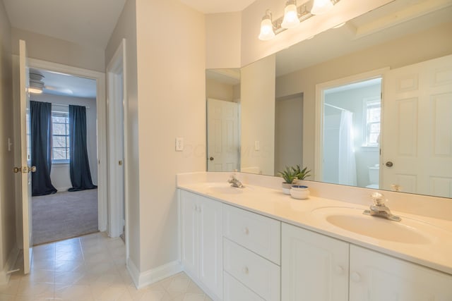 bathroom featuring vanity, tile patterned flooring, toilet, and a wealth of natural light