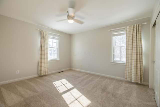 carpeted spare room featuring ceiling fan