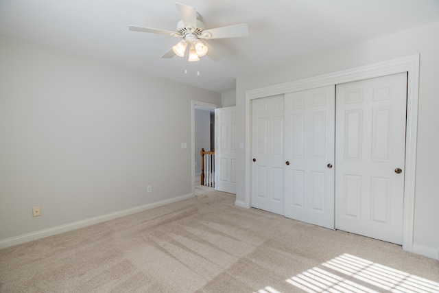 unfurnished bedroom featuring a closet, ceiling fan, and light colored carpet