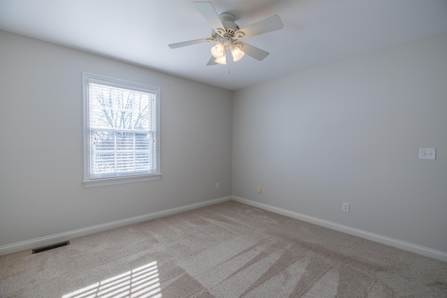 carpeted spare room featuring ceiling fan