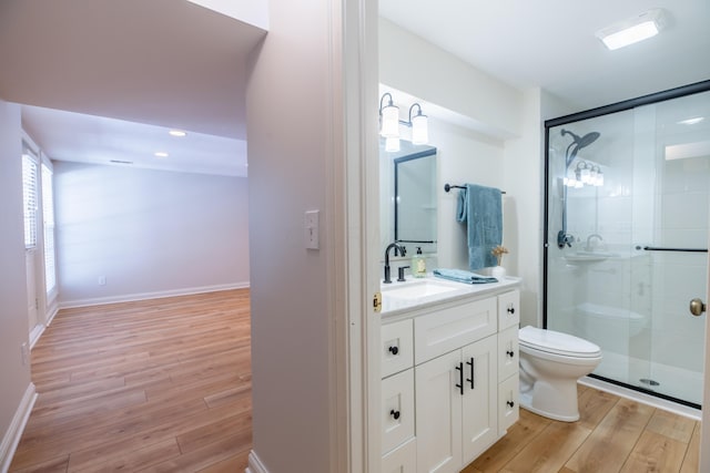 bathroom with wood-type flooring, vanity, toilet, and walk in shower