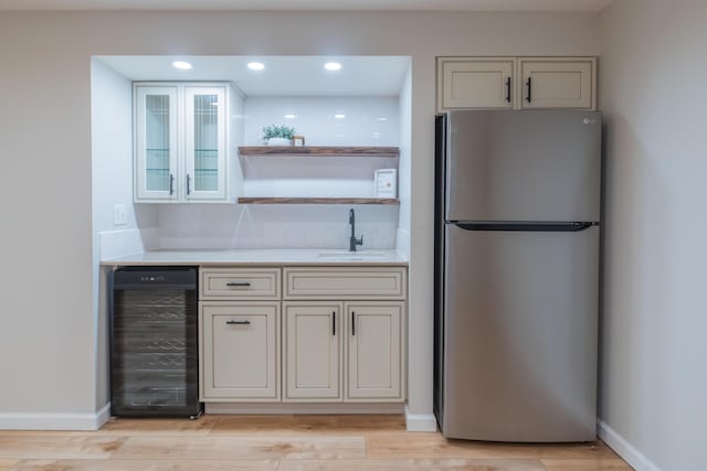 kitchen featuring stainless steel refrigerator, wine cooler, sink, and light hardwood / wood-style flooring