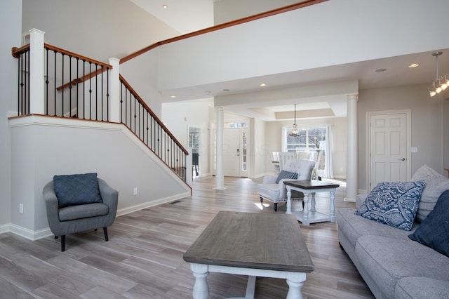 6268 Bellow Valley Dr, Dublin, OH 43016 - living area with a notable chandelier, baseboards, light wood-type flooring, and ornate columns