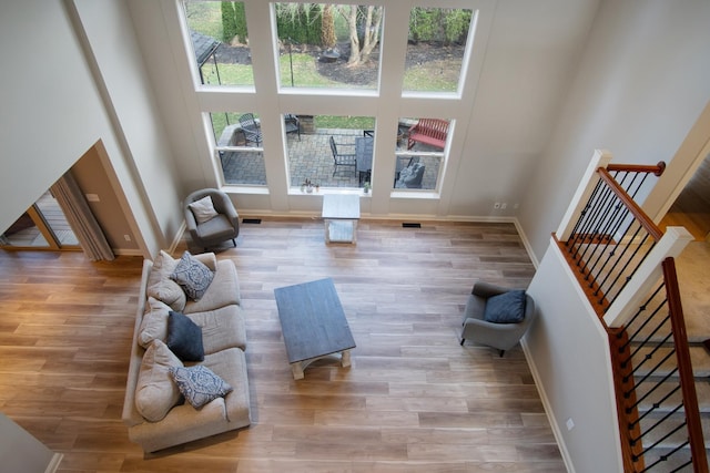 6268 Bellow Valley Dr, Dublin, OH 43016 - living room featuring stairway, wood finished floors, baseboards, and a towering ceiling