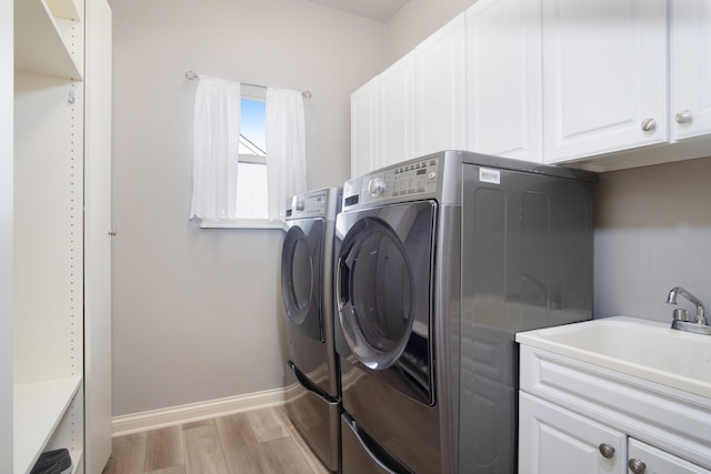 6268 Bellow Valley Dr, Dublin, OH 43016 - laundry area with baseboards, light wood-style floors, cabinet space, independent washer and dryer, and a sink
