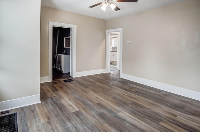 spare room featuring dark wood-type flooring and ceiling fan