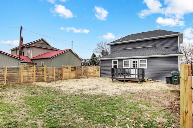 rear view of house with a wooden deck and a yard