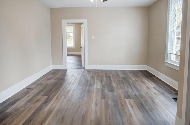 spare room featuring dark wood-type flooring and ceiling fan