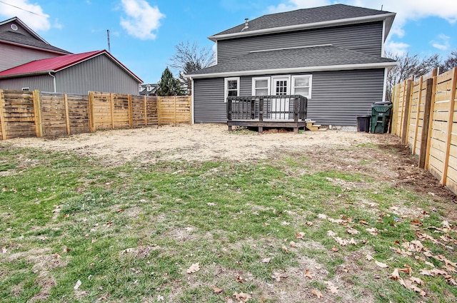 rear view of property with a deck and a lawn