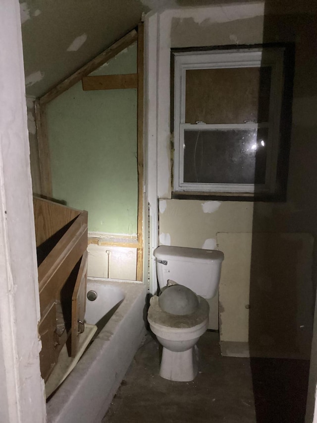 full bathroom with a bath, concrete floors, and toilet