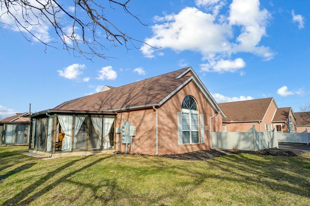 back of house featuring a sunroom and a yard