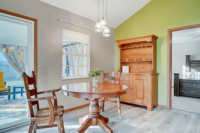 dining space featuring lofted ceiling and light hardwood / wood-style flooring