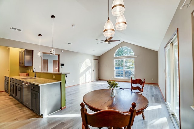 dining space featuring lofted ceiling, sink, light hardwood / wood-style flooring, and ceiling fan