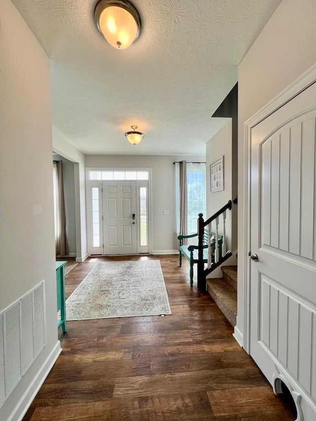 4021 County Road 124, Cardington, OH 43315 - foyer with dark wood-style floors, visible vents, stairs, and a textured ceiling