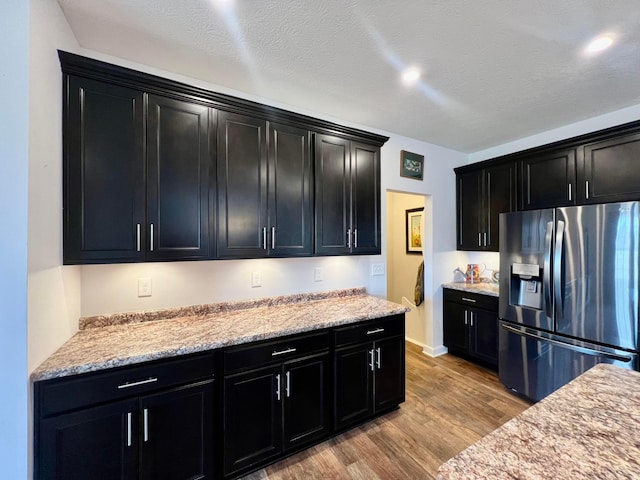 4021 County Road 124, Cardington, OH 43315 - kitchen with stainless steel fridge with ice dispenser, a textured ceiling, light wood-type flooring, and dark cabinets