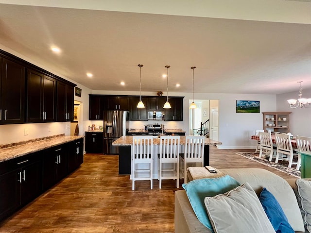 4021 County Road 124, Cardington, OH 43315 - kitchen with a chandelier, a breakfast bar, appliances with stainless steel finishes, open floor plan, and dark wood-type flooring