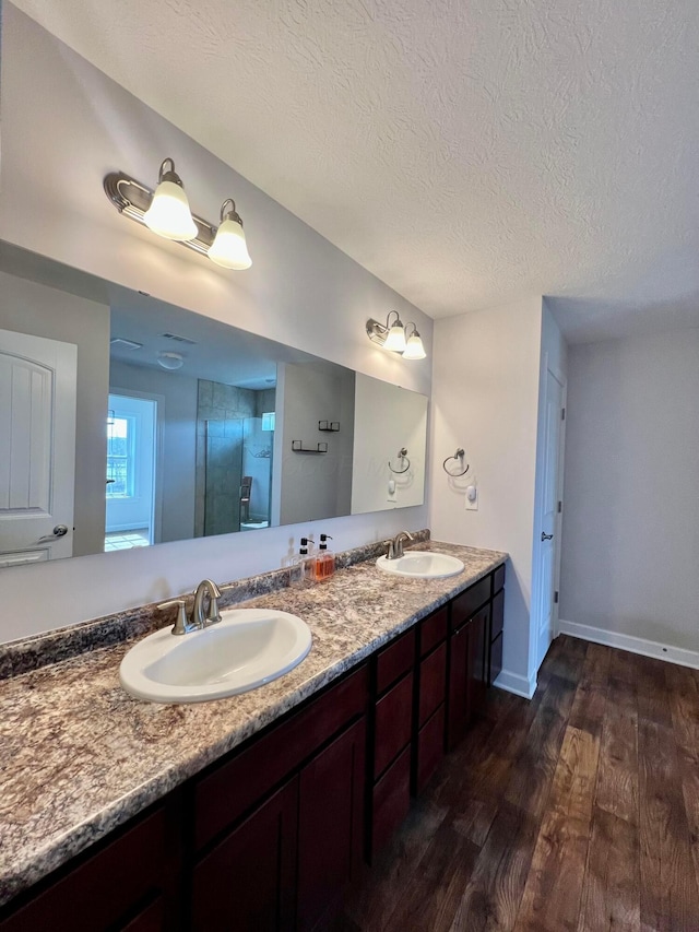 4021 County Road 124, Cardington, OH 43315 - full bathroom featuring double vanity, a textured ceiling, a sink, and wood finished floors