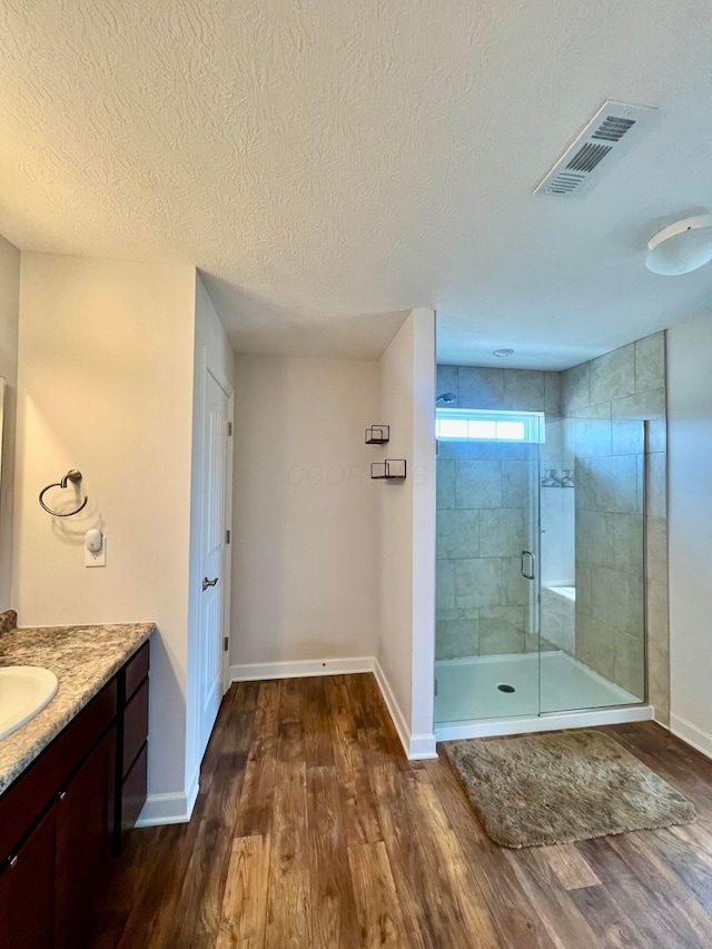4021 County Road 124, Cardington, OH 43315 - bathroom featuring vanity, baseboards, a stall shower, visible vents, and wood finished floors