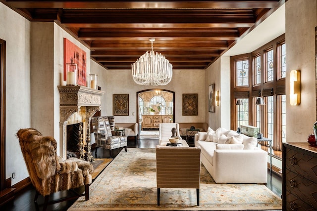 living area with beamed ceiling, a high end fireplace, an inviting chandelier, and wood-type flooring