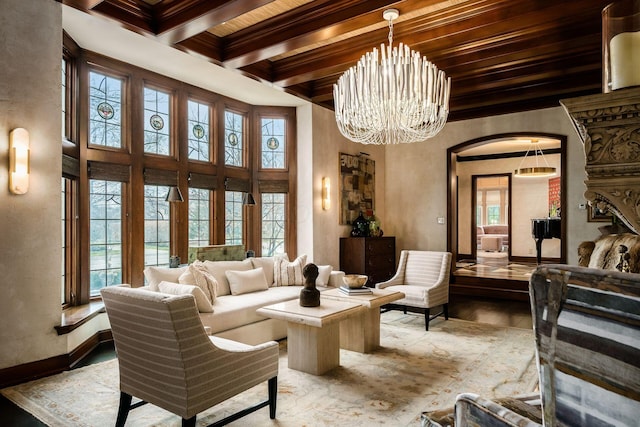 living room with beamed ceiling, ornamental molding, a wealth of natural light, and a notable chandelier