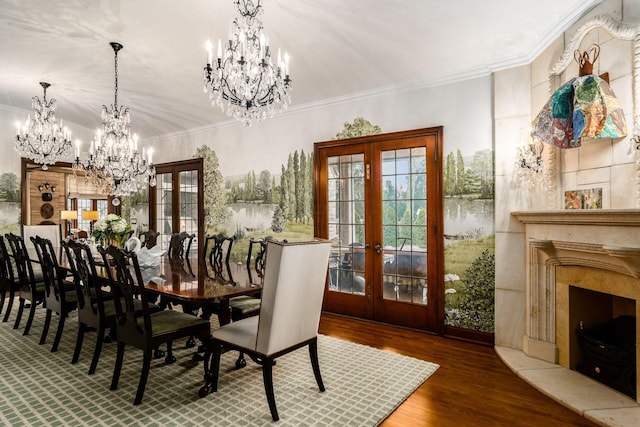 dining room with hardwood / wood-style flooring, crown molding, a notable chandelier, and french doors