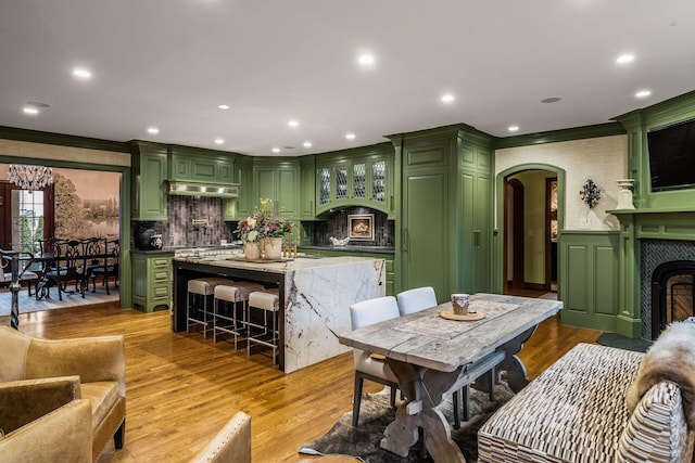 dining area with sink, ornamental molding, and light hardwood / wood-style floors