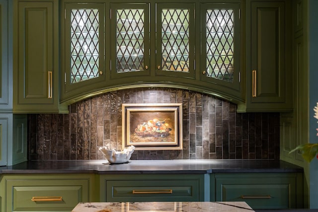 interior details featuring green cabinets and decorative backsplash