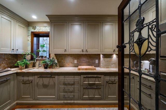 interior space with gray cabinets, sink, and backsplash