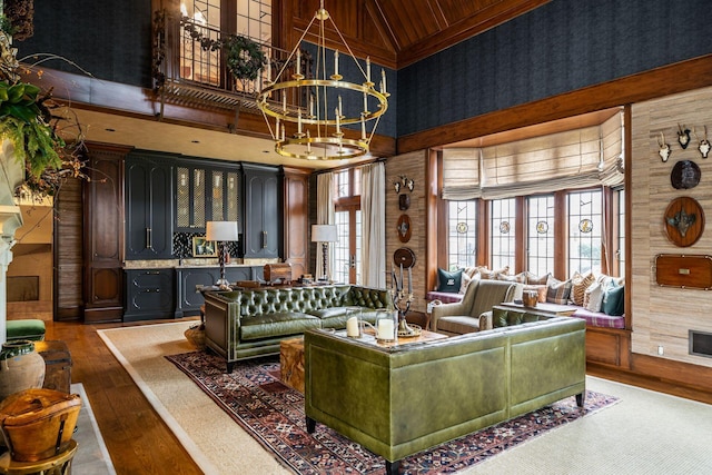 living room featuring an inviting chandelier, hardwood / wood-style flooring, and a high ceiling