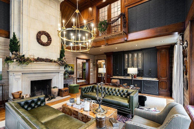 living room featuring hardwood / wood-style flooring, a chandelier, and a high ceiling