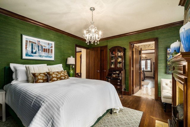 bedroom featuring hardwood / wood-style flooring, ornamental molding, and a notable chandelier