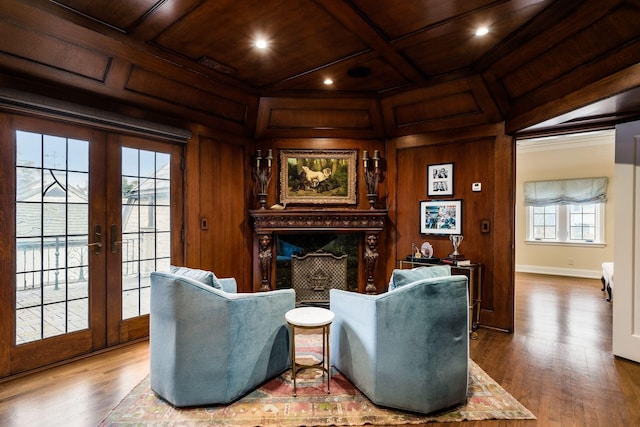 living area featuring coffered ceiling, a high end fireplace, wooden walls, and wooden ceiling