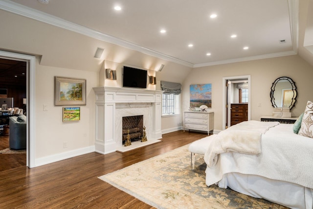 bedroom featuring ornamental molding, a premium fireplace, dark hardwood / wood-style floors, and vaulted ceiling