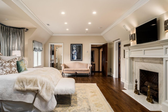 bedroom with crown molding, dark wood-type flooring, and a high end fireplace