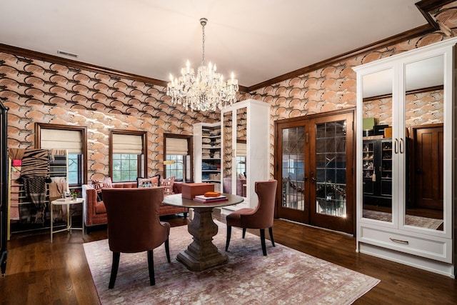 dining room with crown molding, dark hardwood / wood-style floors, a chandelier, and french doors