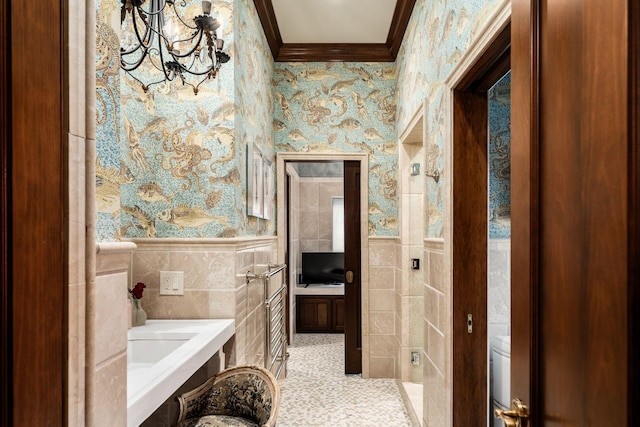 bathroom featuring crown molding, a chandelier, and tile walls