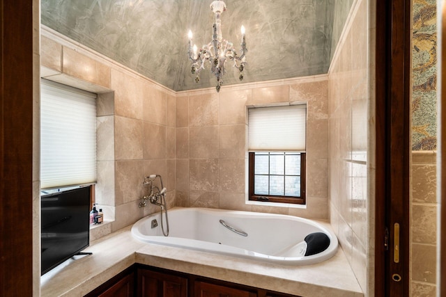 bathroom featuring tile walls, tiled tub, and an inviting chandelier