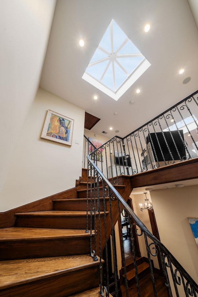 stairs with wood-type flooring and a notable chandelier