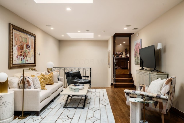 living room with wood-type flooring and a skylight