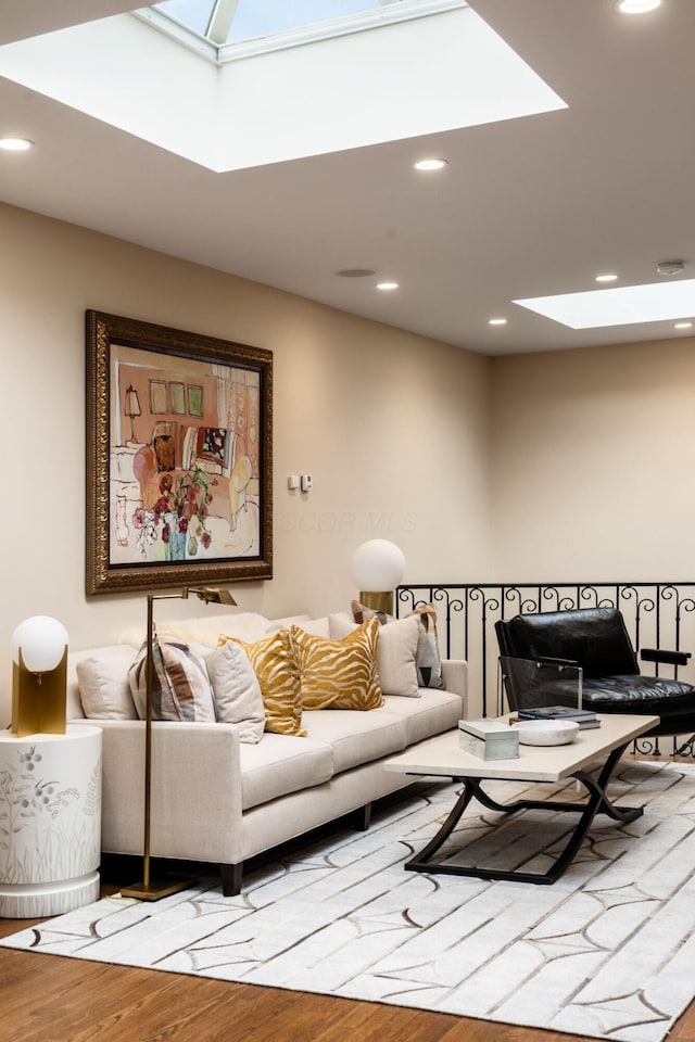 living room with hardwood / wood-style floors and a skylight